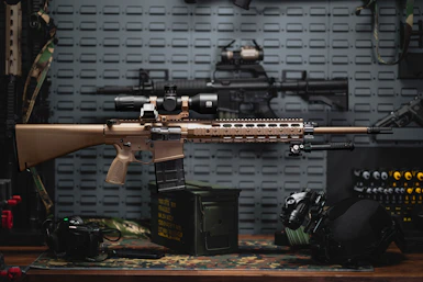 a rifle on a table next to other items