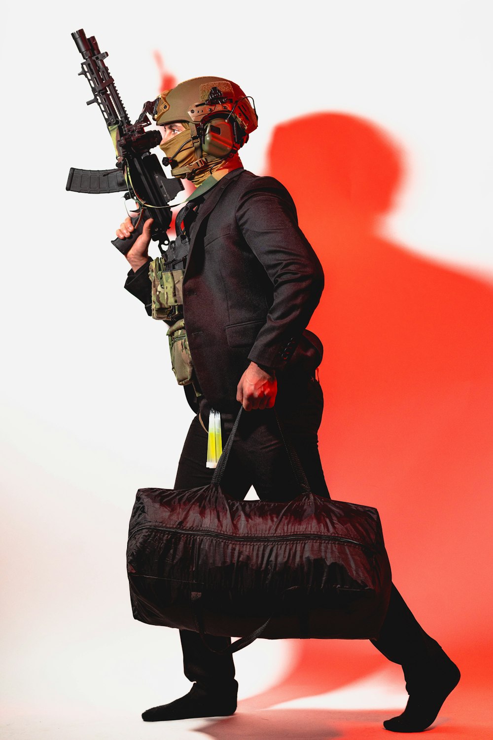 a man in a suit carrying a bag and a gun