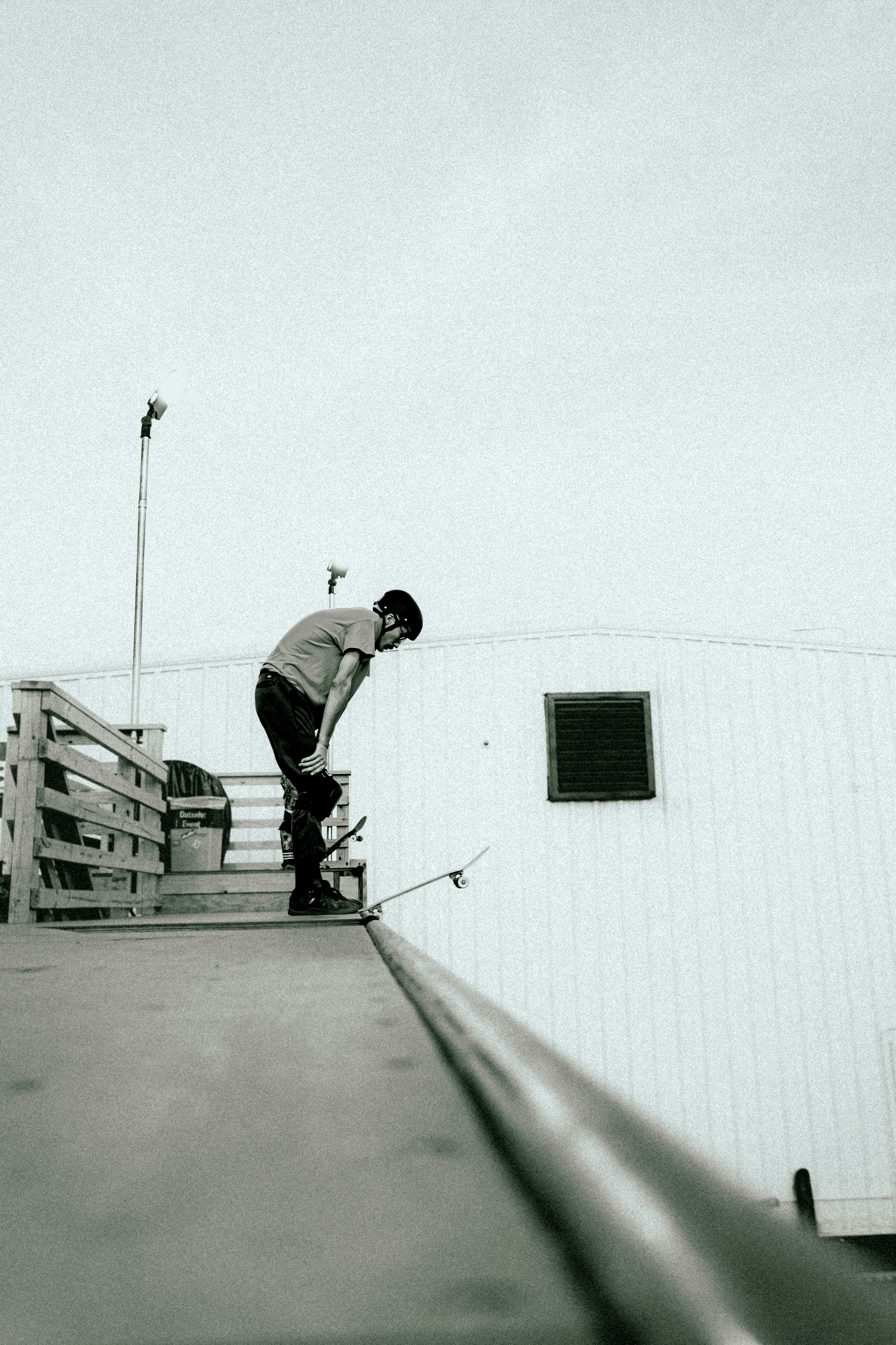 スロープの脇をスケートボードで下る男性