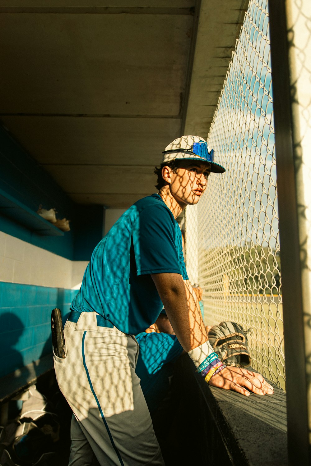 a man standing next to a fence holding a baseball bat