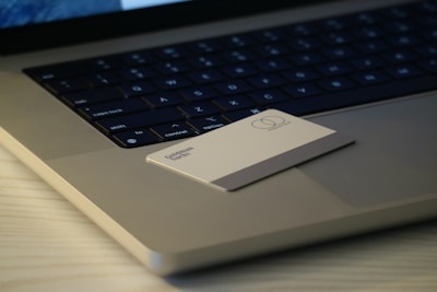 Close-up of a sleek NFC networking card glowing softly on a wooden desk.