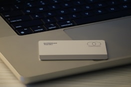 A credit card featuring the logos of Goldman Sachs and Mastercard is placed on the keyboard of a laptop. The laptop has visible keys such as 'shift', 'fn', and 'control'. The setup is minimalist with concentrated focus on the card and keyboard.