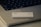 A credit card featuring the logos of Goldman Sachs and Mastercard is placed on the keyboard of a laptop. The laptop has visible keys such as 'shift', 'fn', and 'control'. The setup is minimalist with concentrated focus on the card and keyboard.