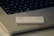 A credit card featuring the logos of Goldman Sachs and Mastercard is placed on the keyboard of a laptop. The laptop has visible keys such as 'shift', 'fn', and 'control'. The setup is minimalist with concentrated focus on the card and keyboard.