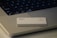 A credit card featuring the logos of Goldman Sachs and Mastercard is placed on the keyboard of a laptop. The laptop has visible keys such as 'shift', 'fn', and 'control'. The setup is minimalist with concentrated focus on the card and keyboard.