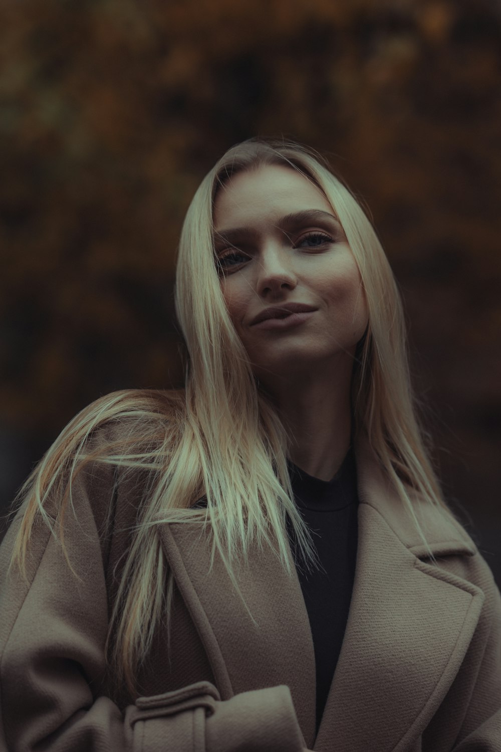 a woman with blonde hair wearing a coat