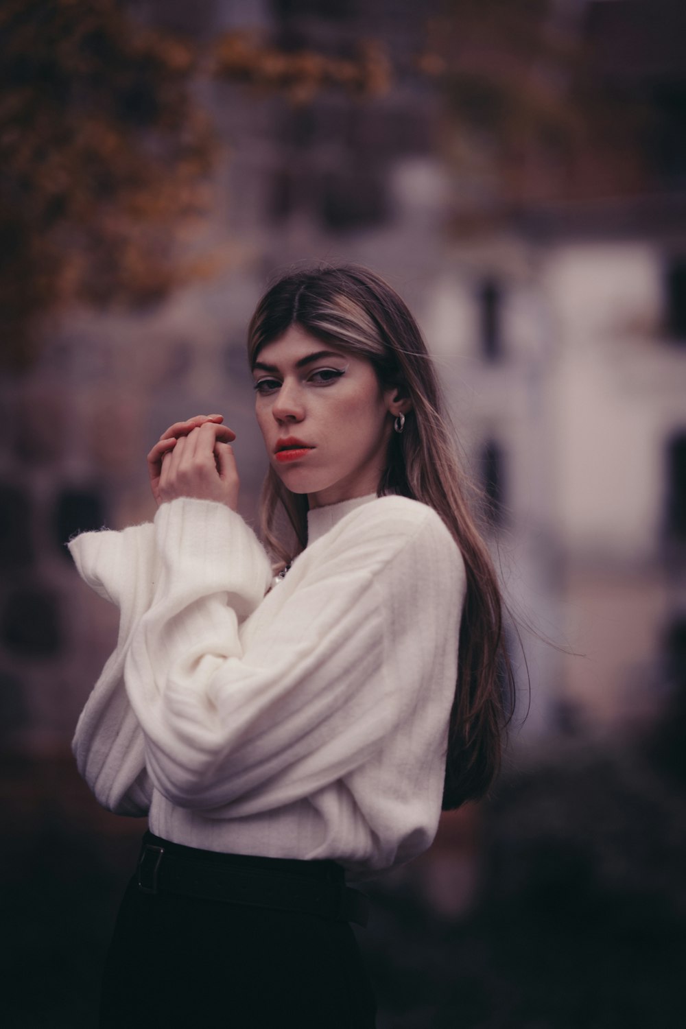 a woman with long hair wearing a white sweater