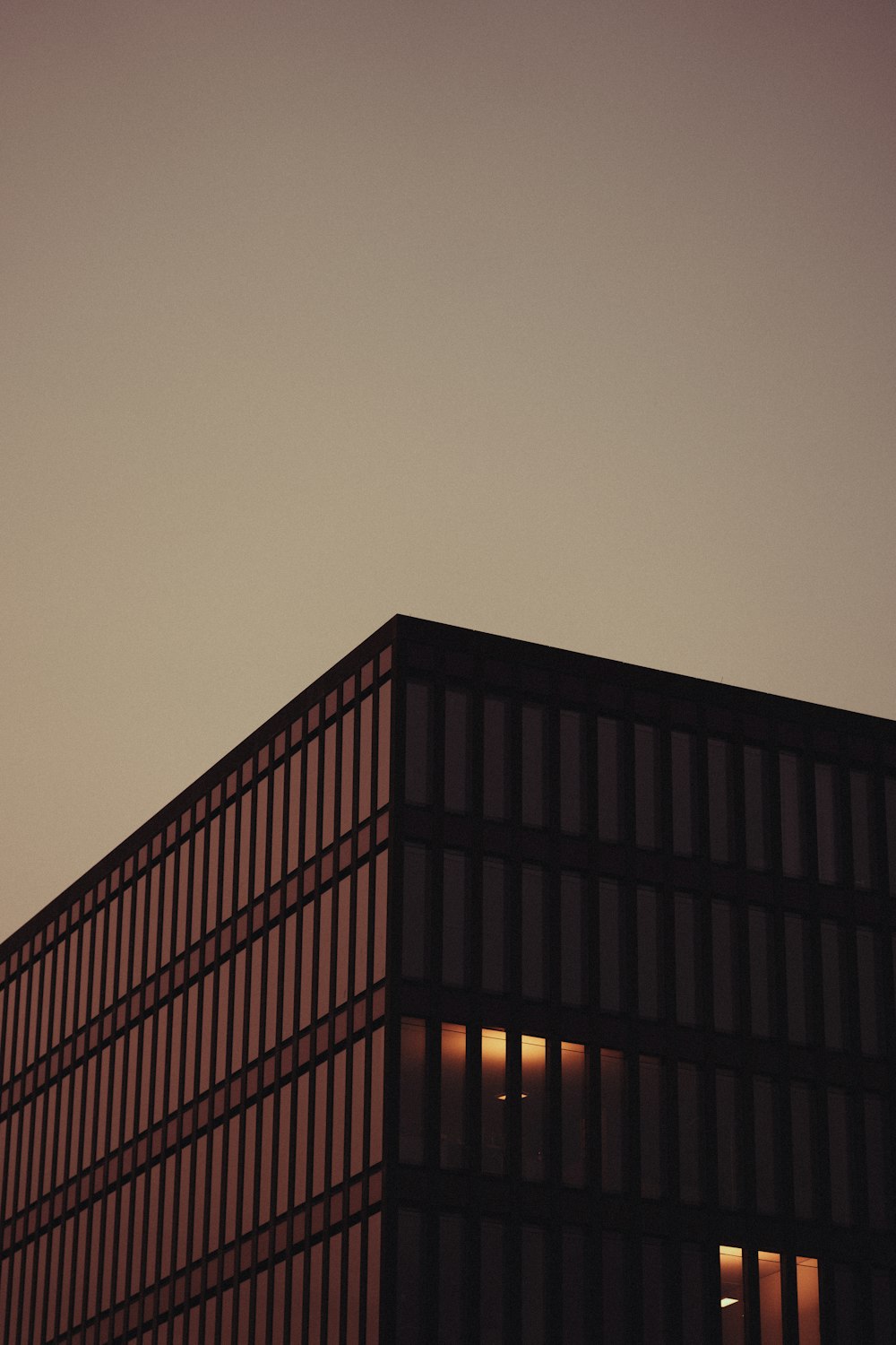 an airplane flying over a building at dusk