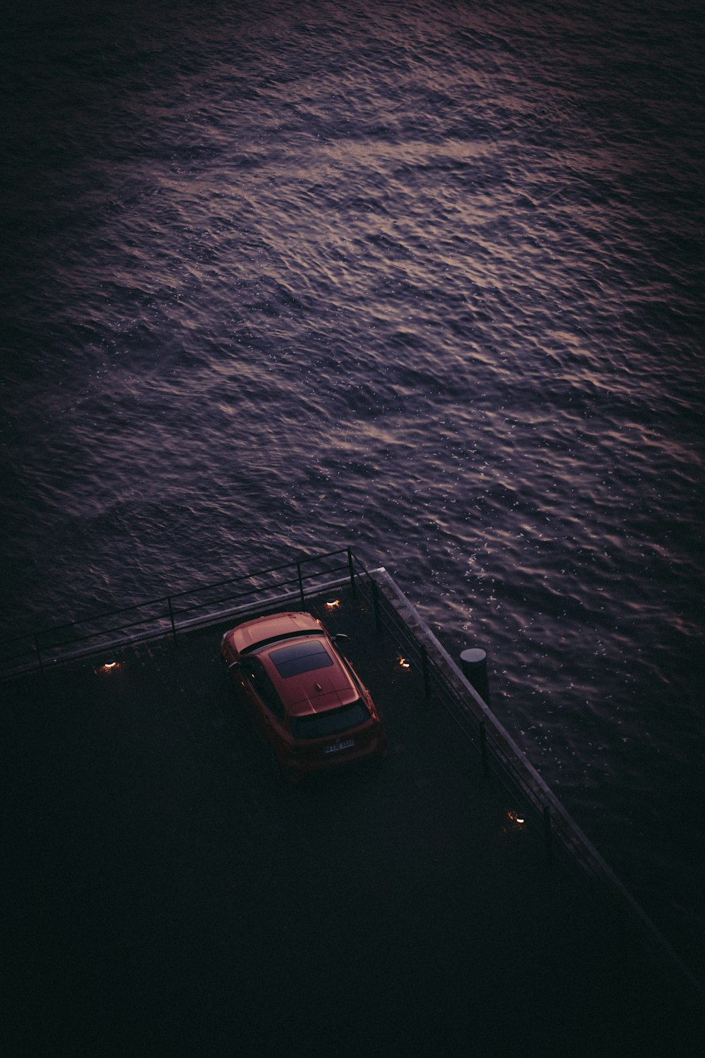 a car is parked on a dock by the water