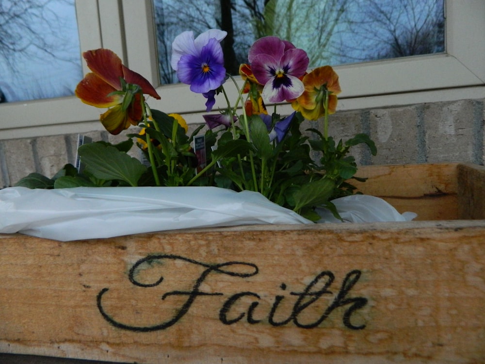 a wooden box with flowers in it that says faith