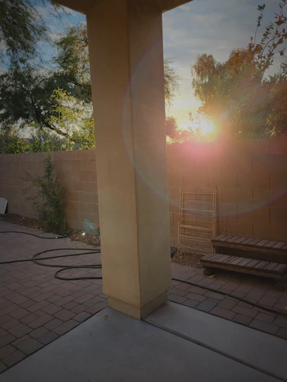 A warm sunset casting golden light over a freshly built wooden deck and fence surrounding a cozy backyard.