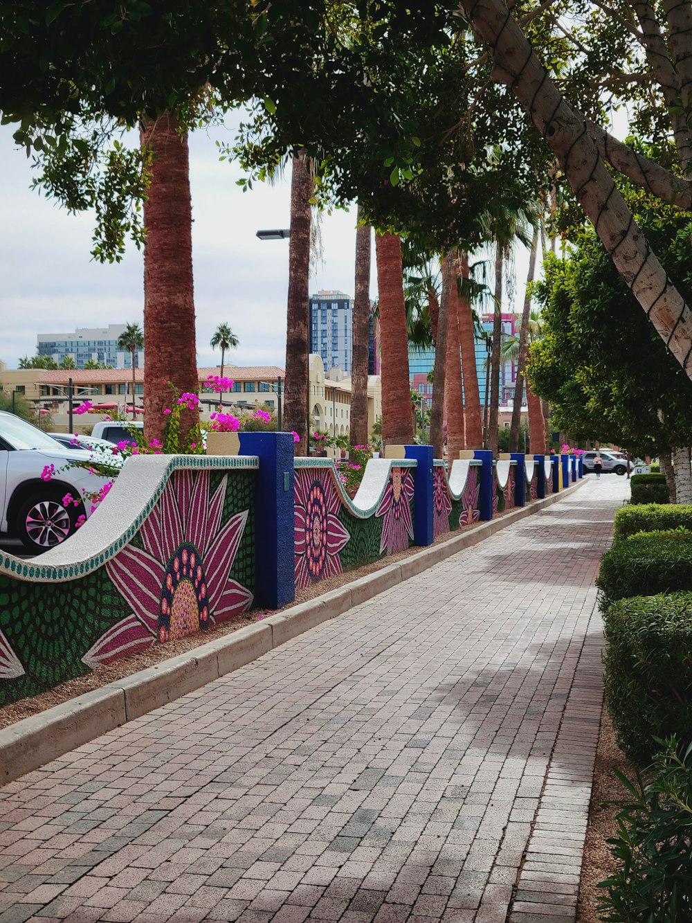 a brick sidewalk with a mural on the side of it