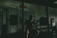 A trainer demonstrating proper form for a squat in a bright home gym.