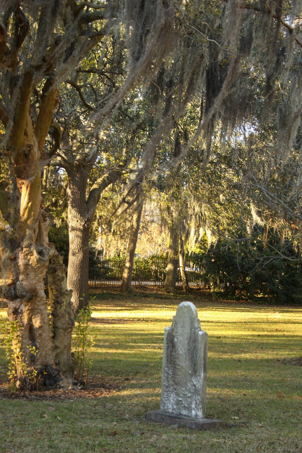 a stone monument in a grassy area with trees in the background