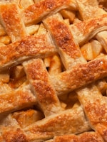 Close-up of a rich, golden-baked apple pie with a flaky crust