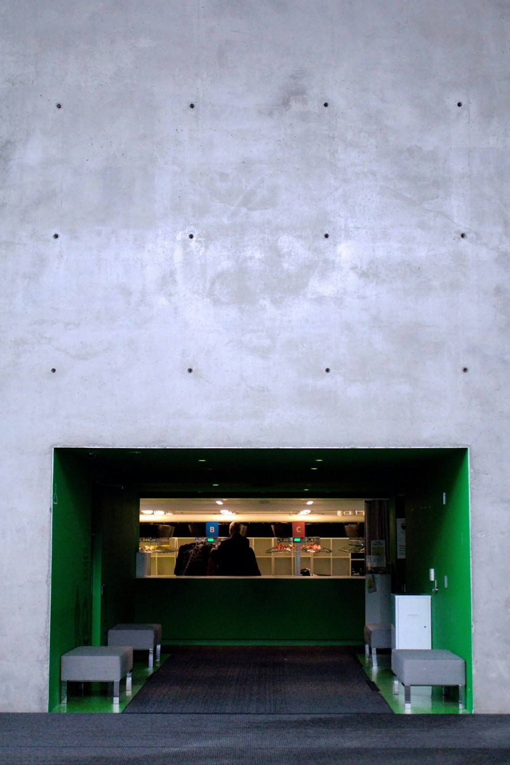 a white building with a green door and some benches