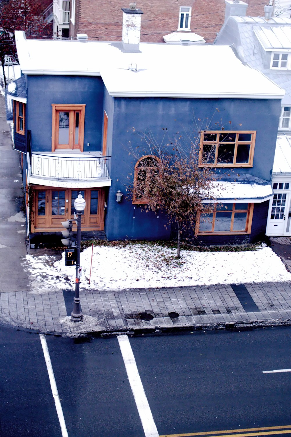 uma casa azul em uma esquina com neve no chão
