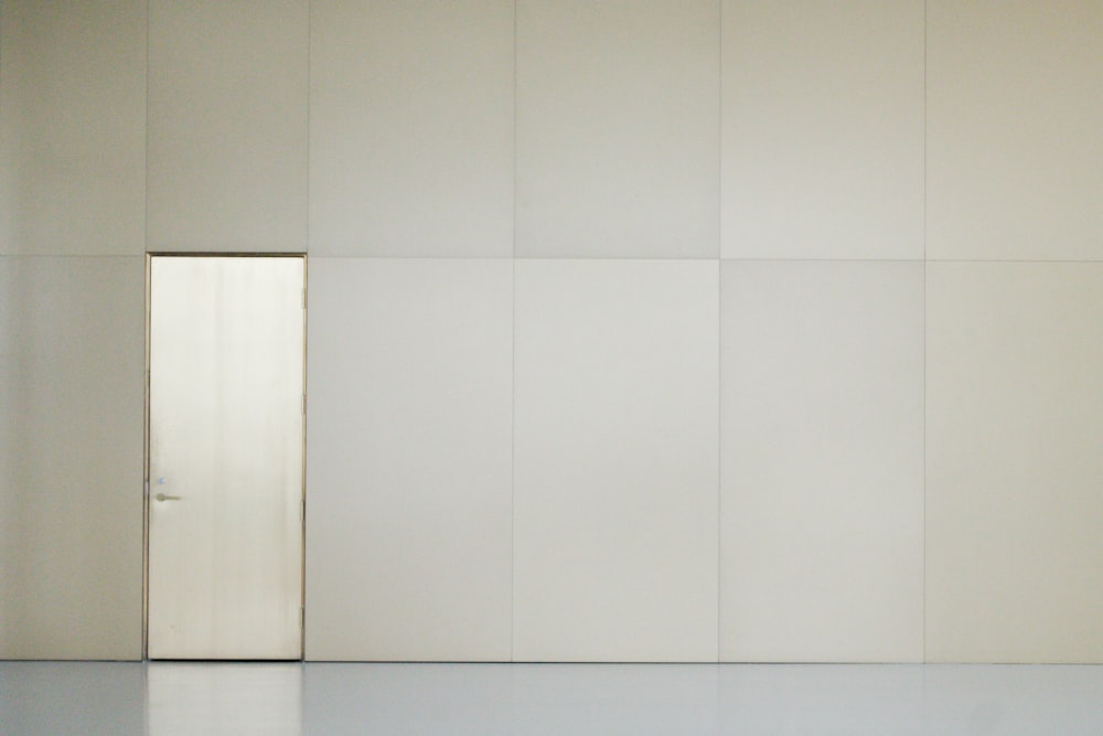an empty room with a door and a white wall