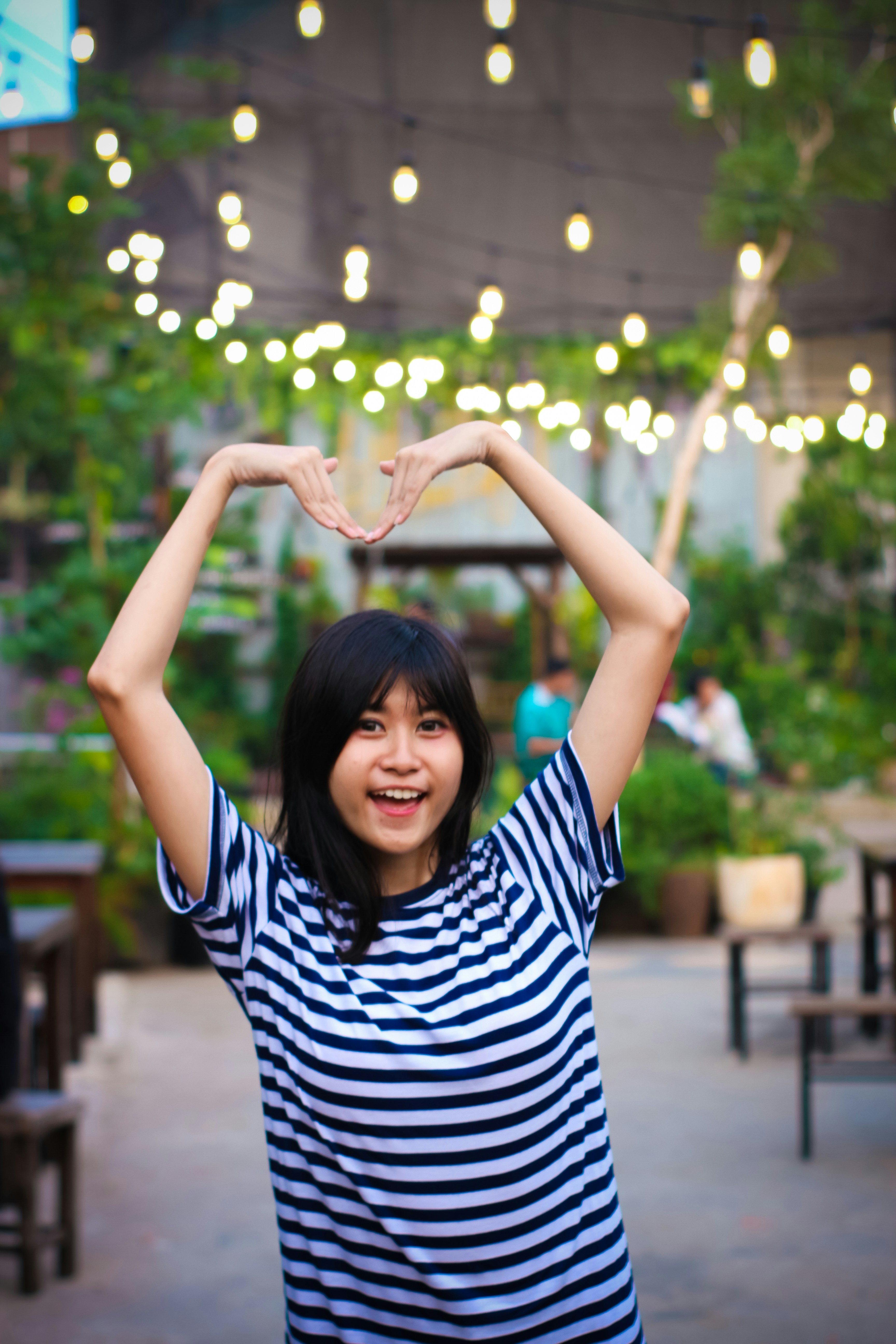 eine Frau, die mit ihren Händen ein Herz macht