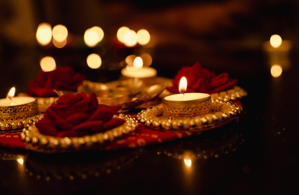 a table topped with candles and roses on top of it