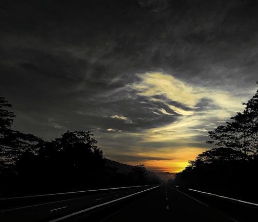 Wide shot of a newly paved highway stretching into the horizon at dusk
