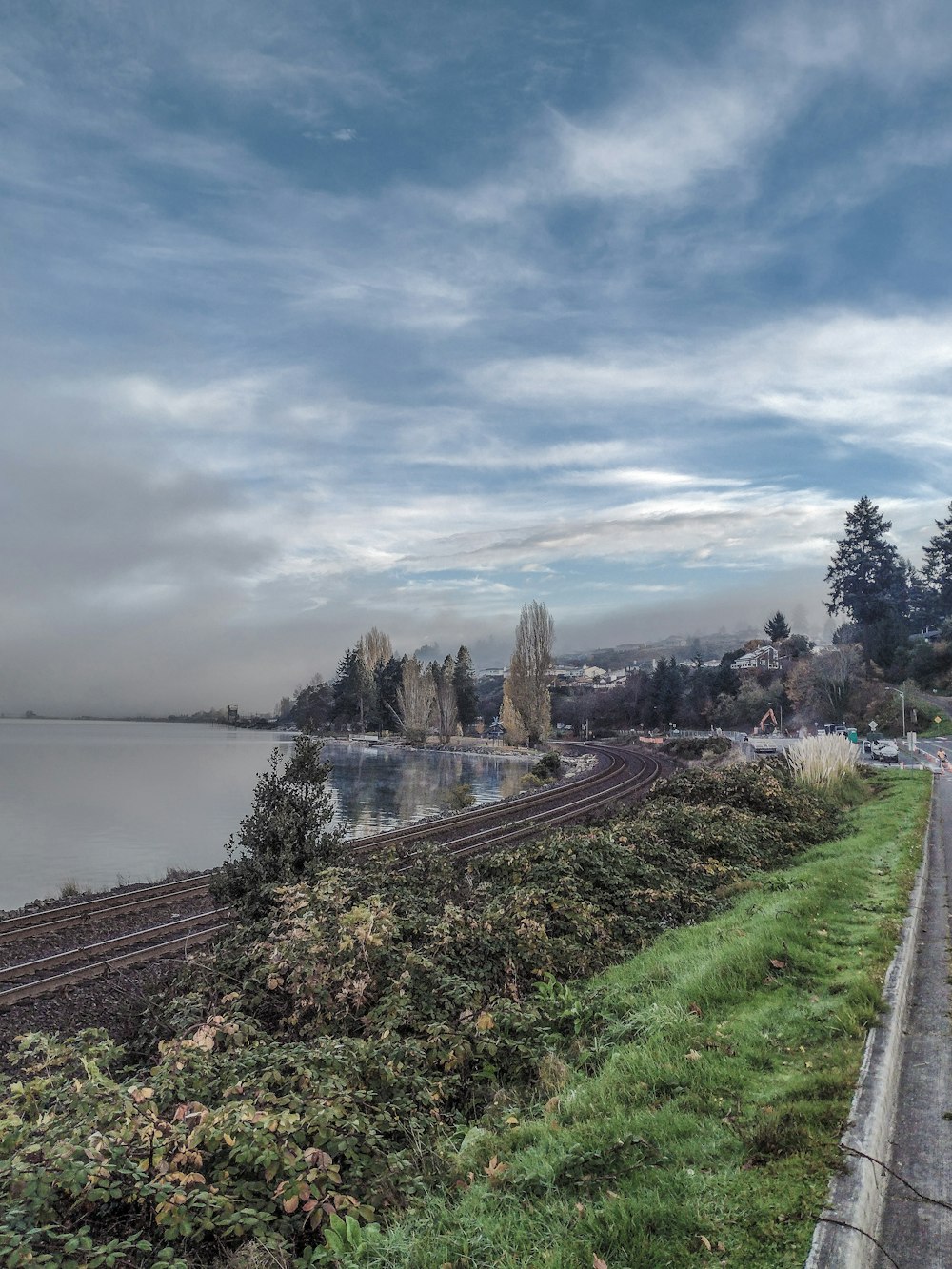 a train traveling down tracks next to a body of water