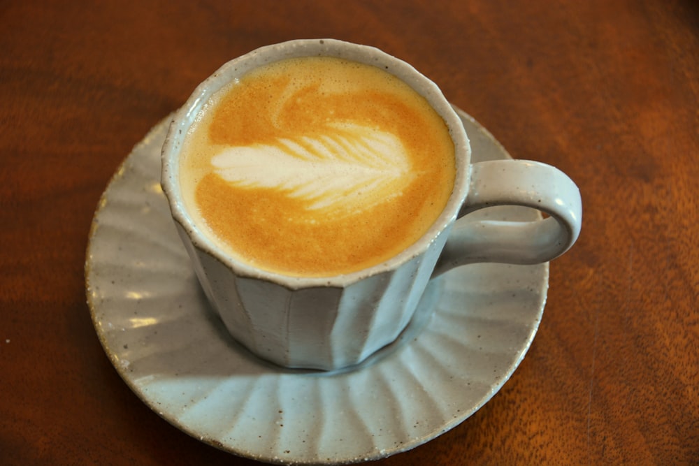 a cup of coffee on a saucer on a wooden table