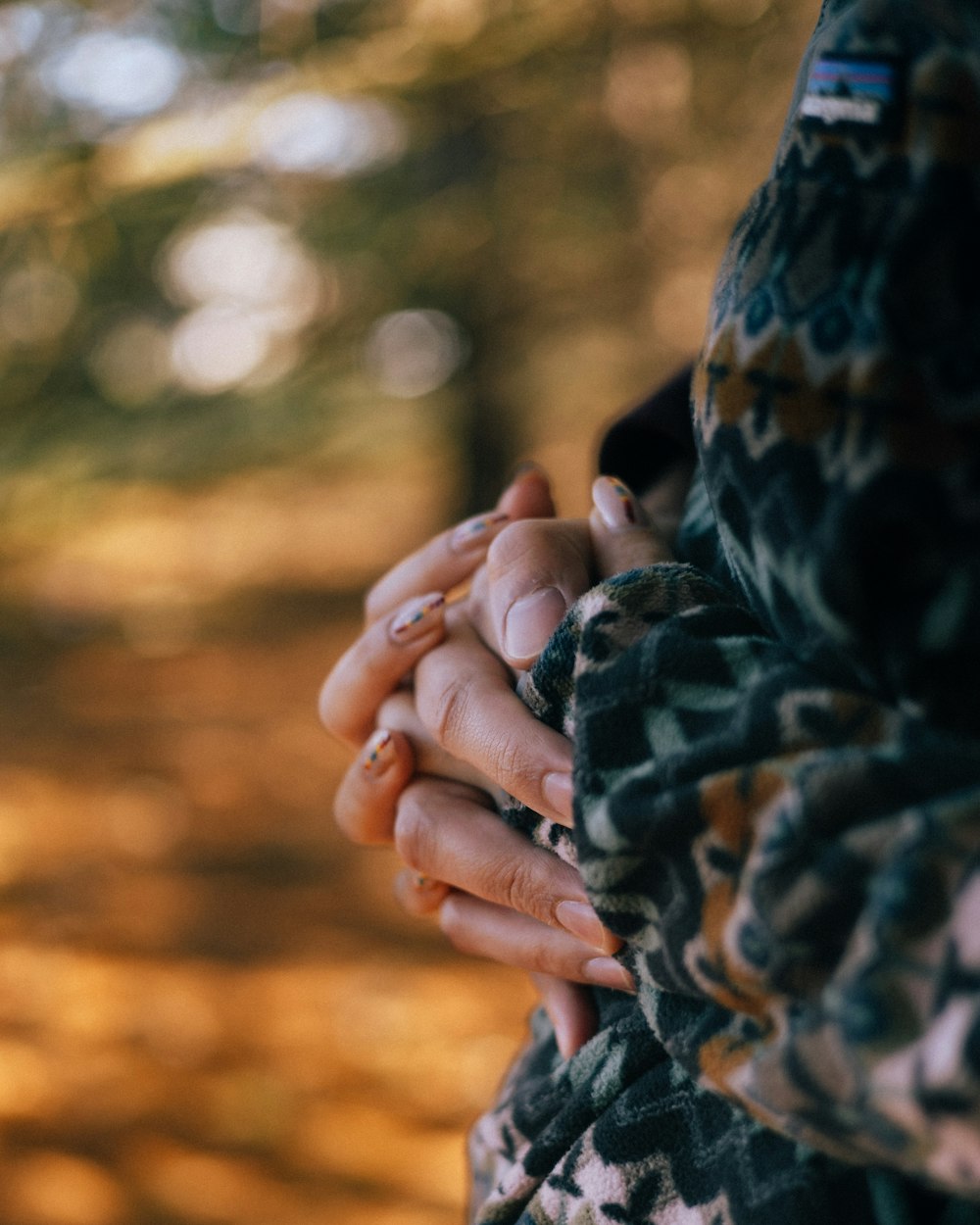 a woman holding a man's hands in a forest