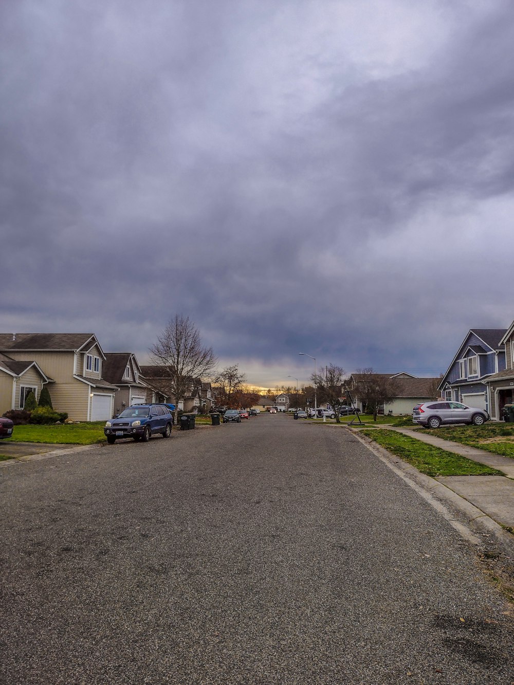 a street lined with houses under a cloudy sky