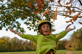 A cheerful child wearing colorful seasonal clothing from the yêuthương juni collection, playing outdoors.