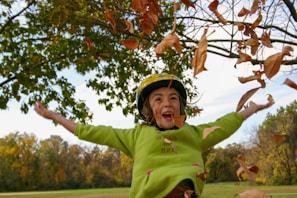 A joyful child wearing a safety helmet while riding a bicycle.