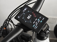 Close-up of an ebike's handlebar and digital display glowing softly at dusk.