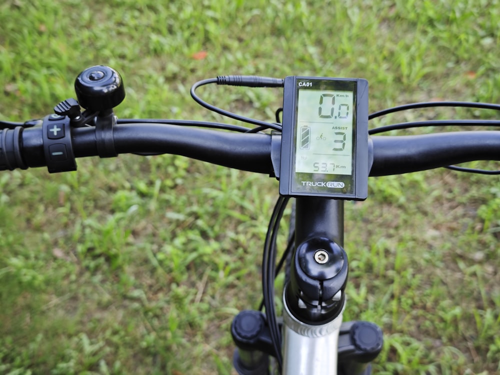 a close up of a bike handlebar with a clock on it