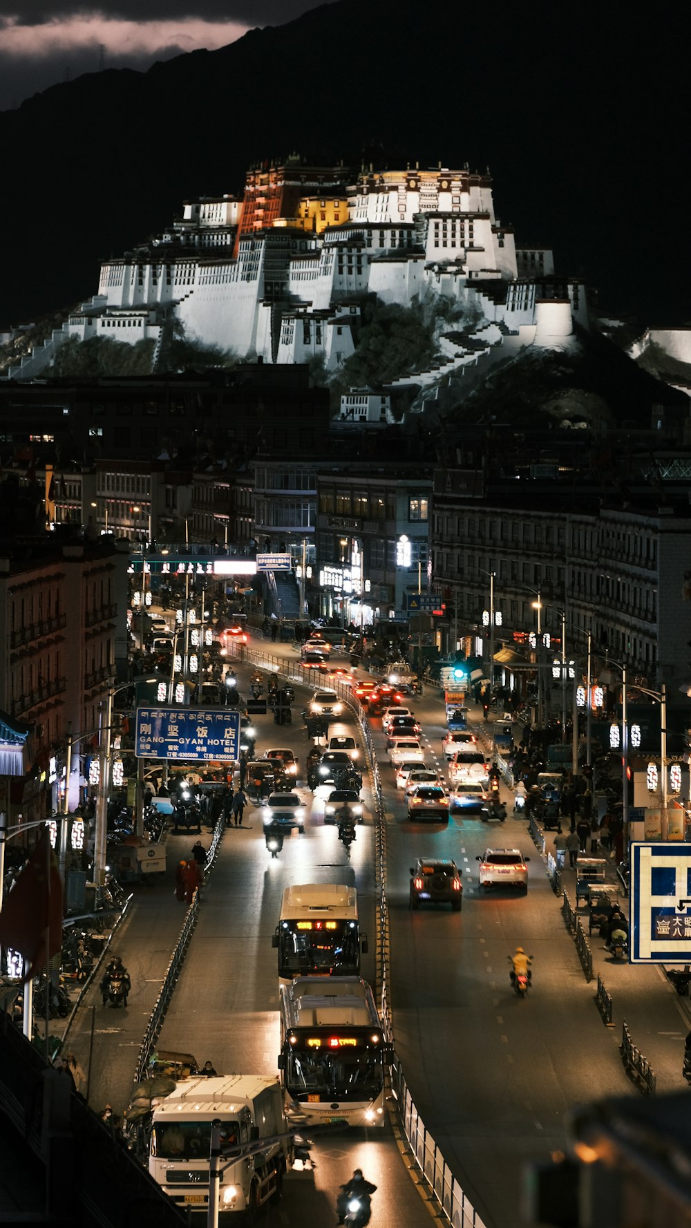 a city street at night with a large building on top of it