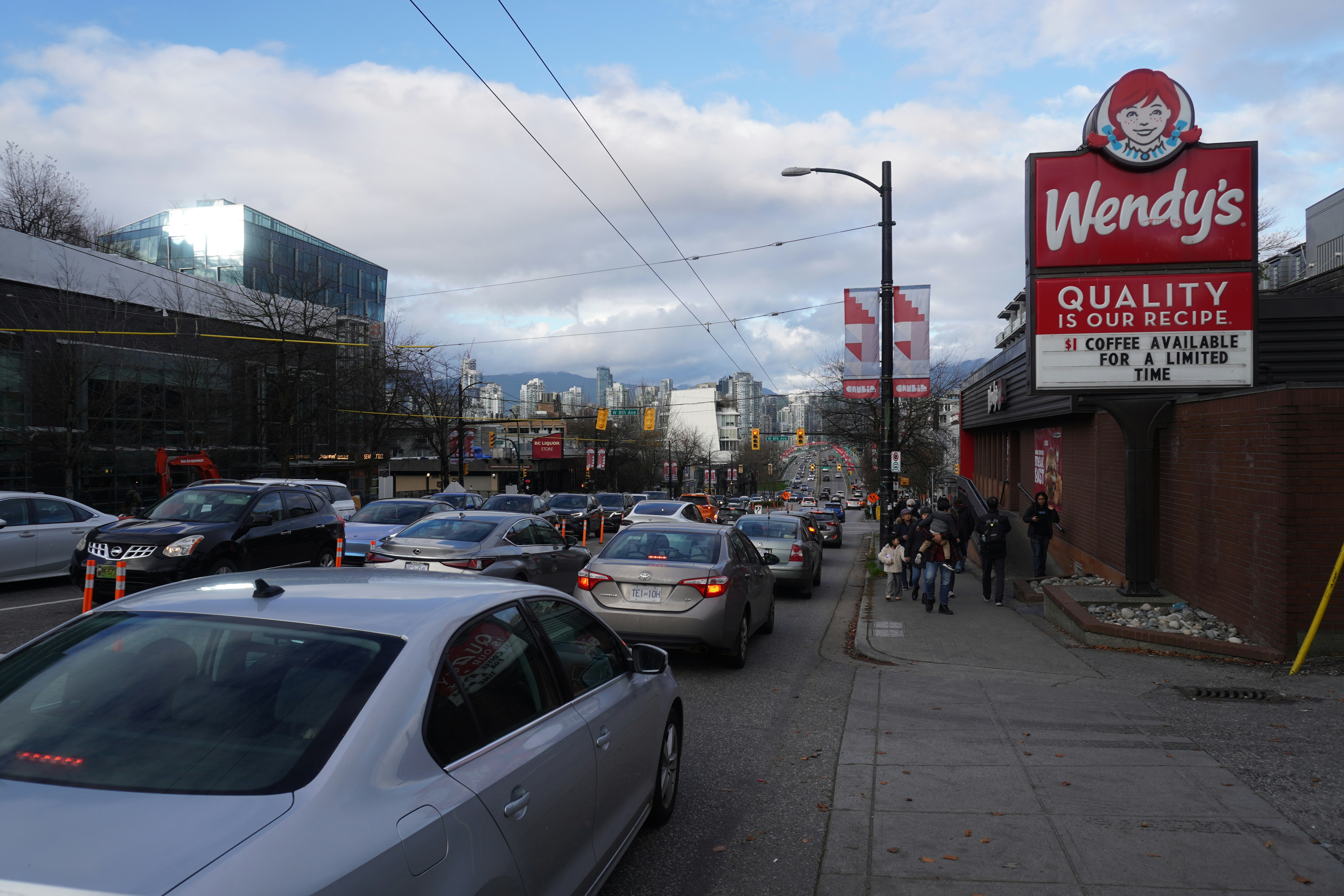 a busy city street with cars parked on the side of the road
