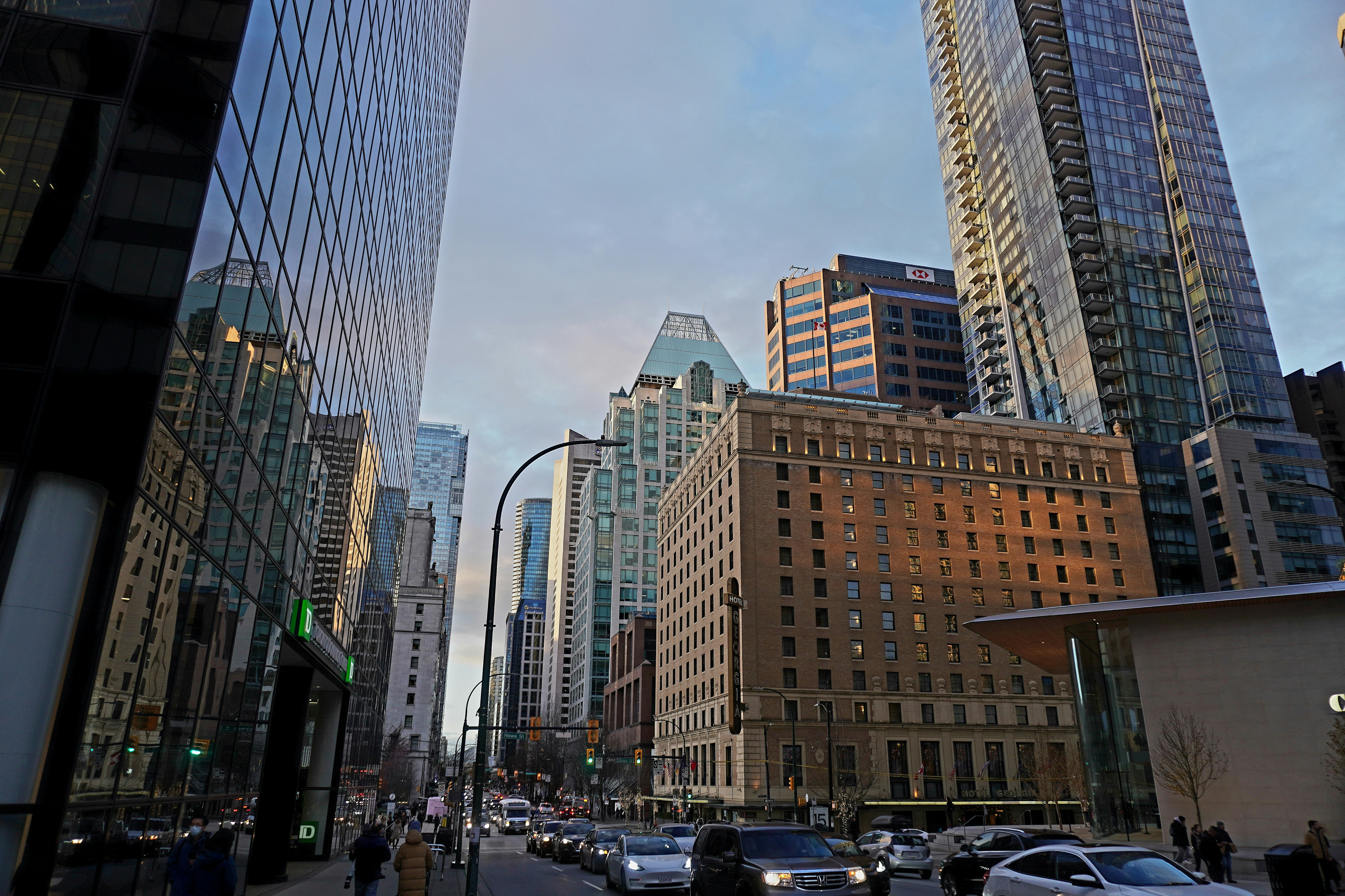 a city street filled with lots of tall buildings, A view of the Rosewood hotel Georgia surrounded by glittering skyscrapers