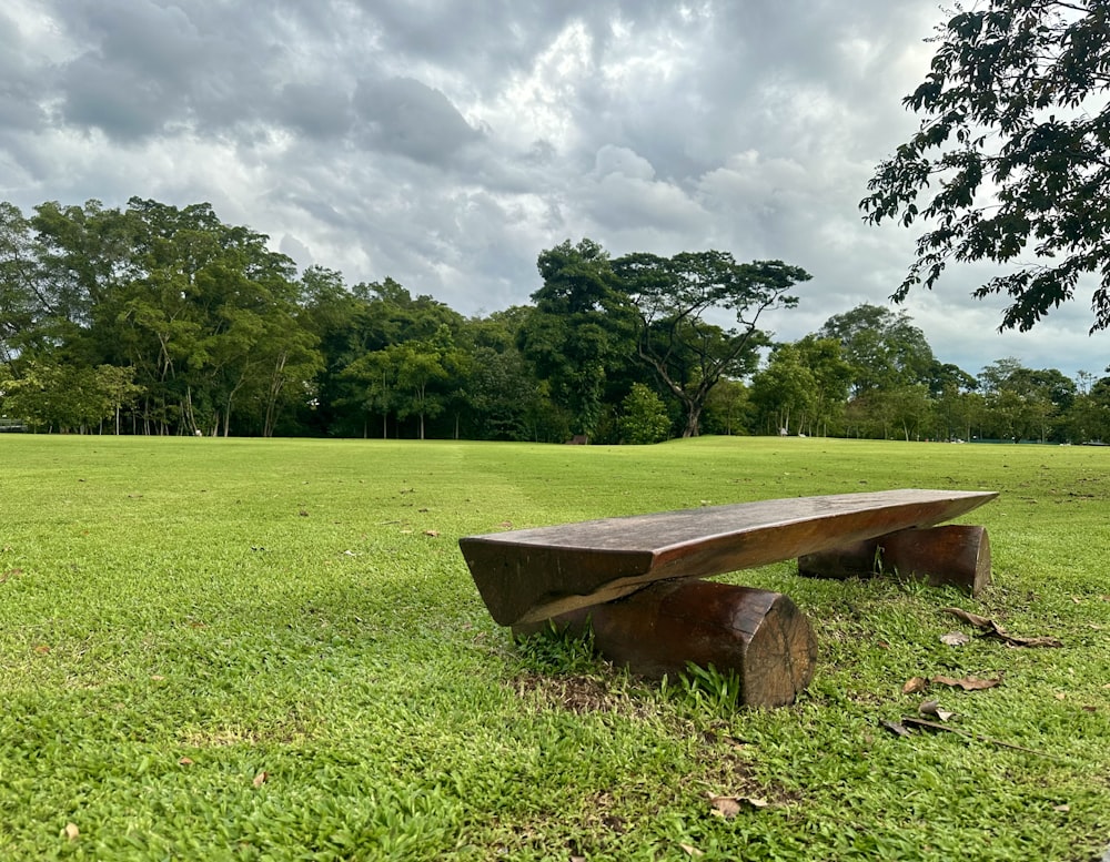 a wooden bench sitting on top of a lush green field