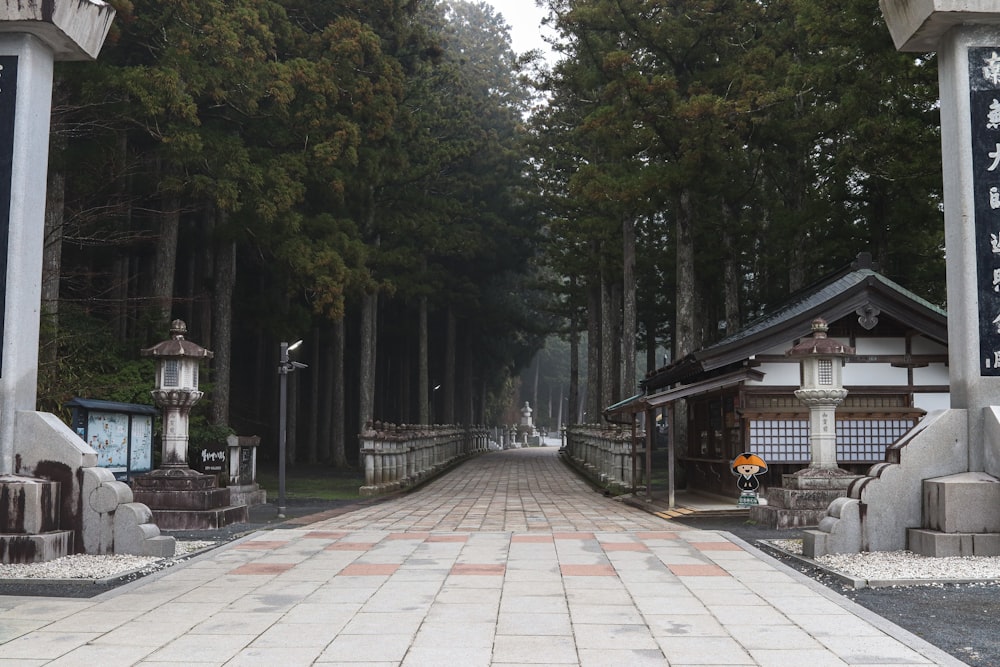 a walkway lined with trees and lanterns in a park