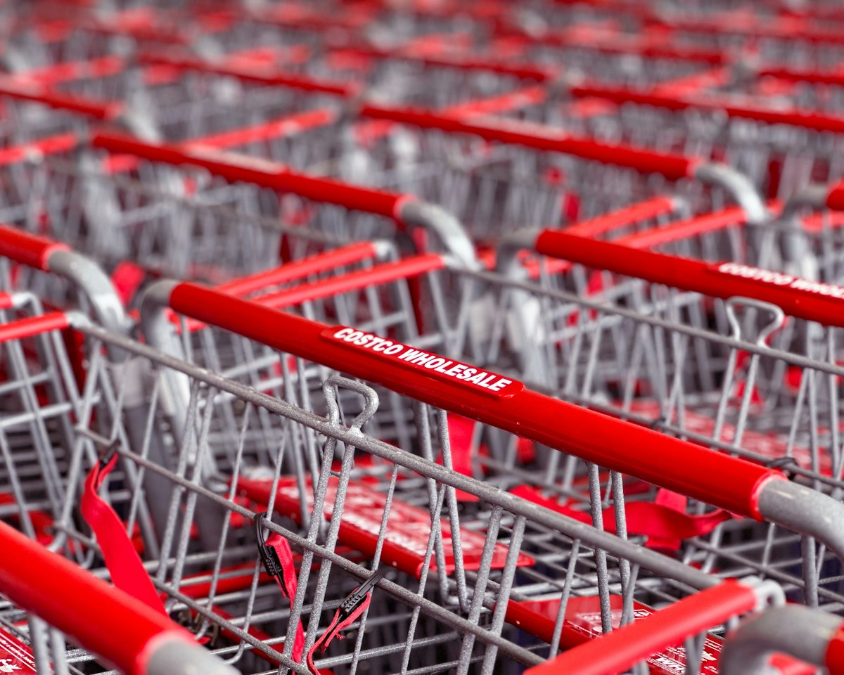 Rows of Costco Wholesale shopping carts lined up in a warehouse store