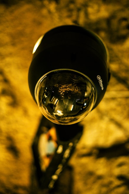 A close-up of a security surveillance camera mounted on a wall.