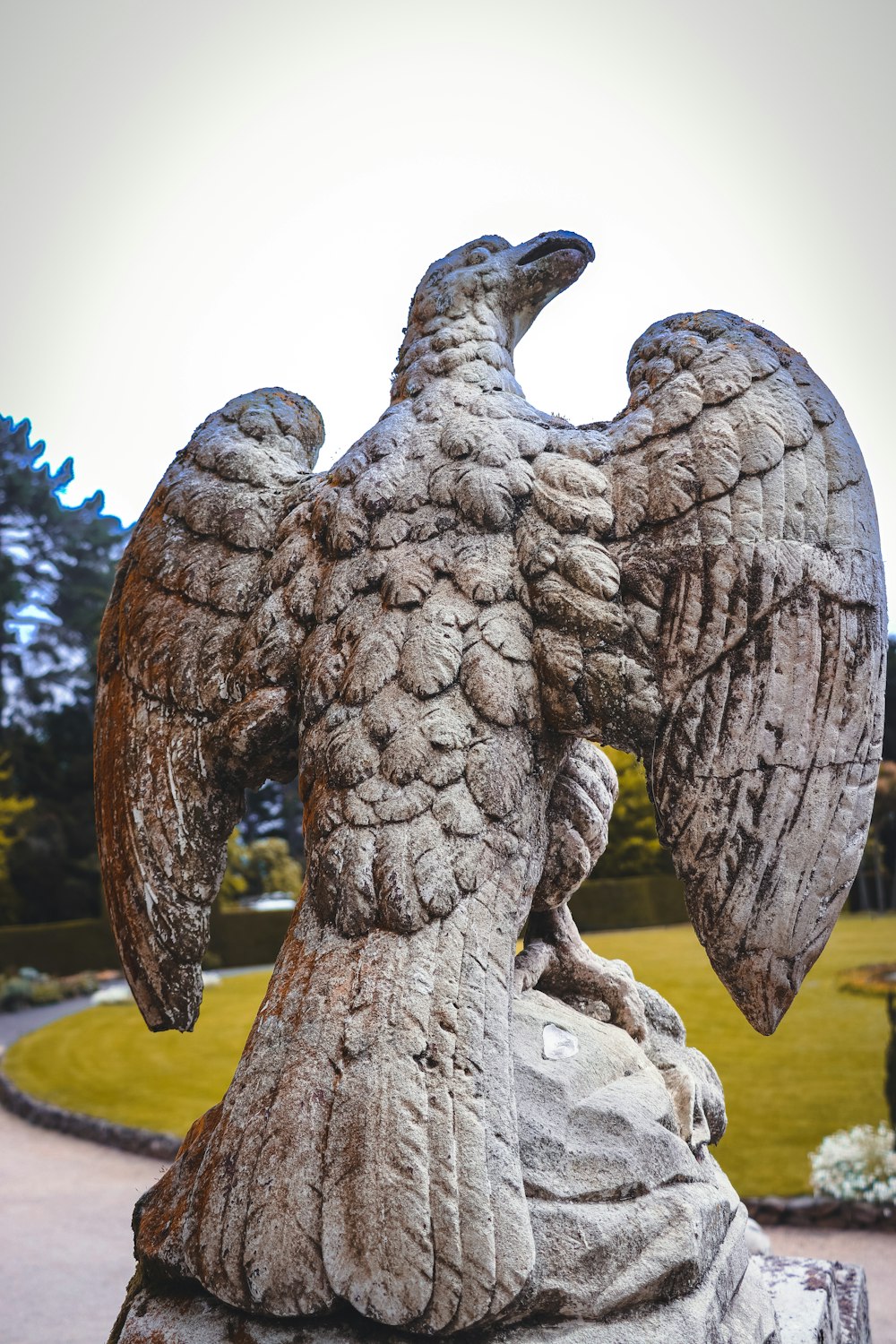 a statue of an eagle on a rock in a park