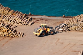 a tractor is parked next to a pile of logs