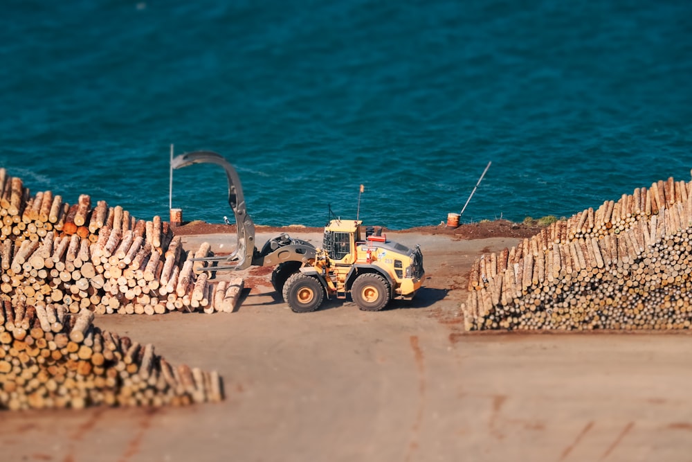 a tractor is parked next to a pile of logs