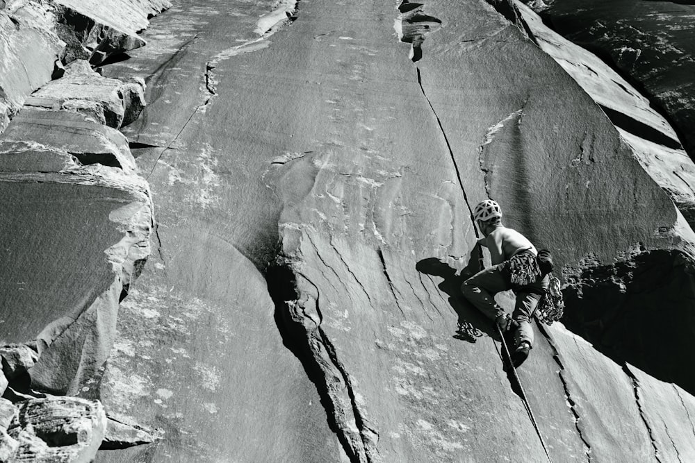 a man climbing up the side of a mountain