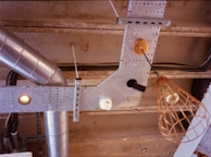 A cluster of industrial retro pendant lights hanging from a rustic ceiling beam.