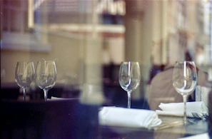 Casual daytime scene of a restaurant team preparing wine bottles and arranging tables with care.