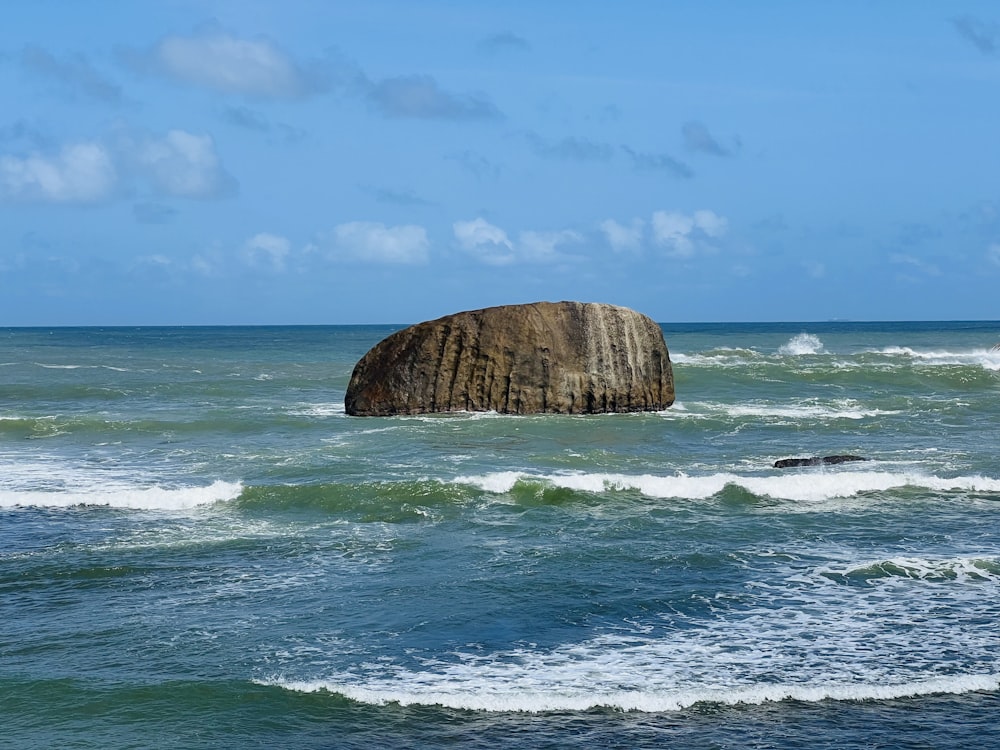 a large rock sticking out of the ocean