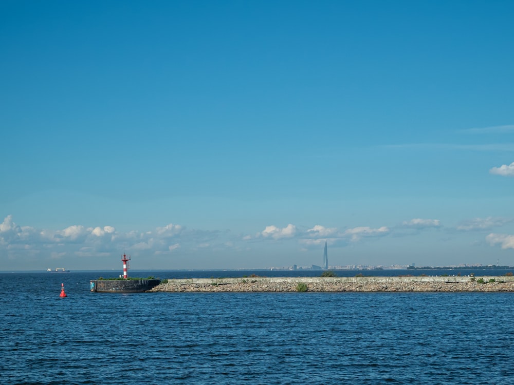 a large body of water with a lighthouse in the distance