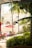 A tropical patio with lounge chairs under red umbrellas and palm trees, set against a backdrop of an elegant building with arched windows and balconies. The area is surrounded by lush greenery and sunlight filters through the leaves, creating a serene and inviting atmosphere.