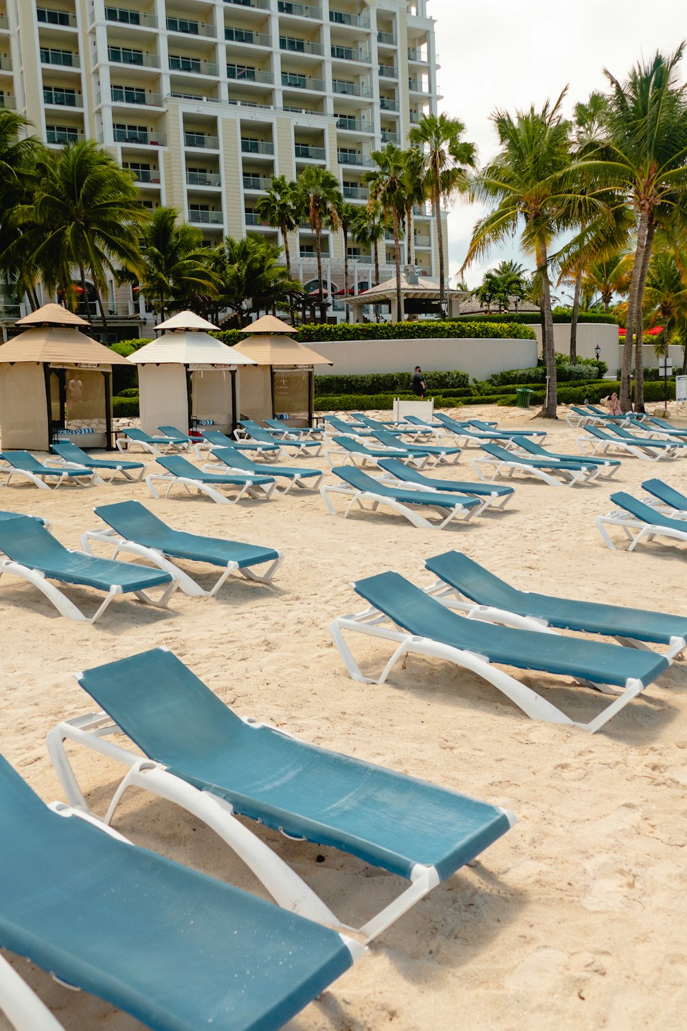 a bunch of lawn chairs that are sitting in the sand